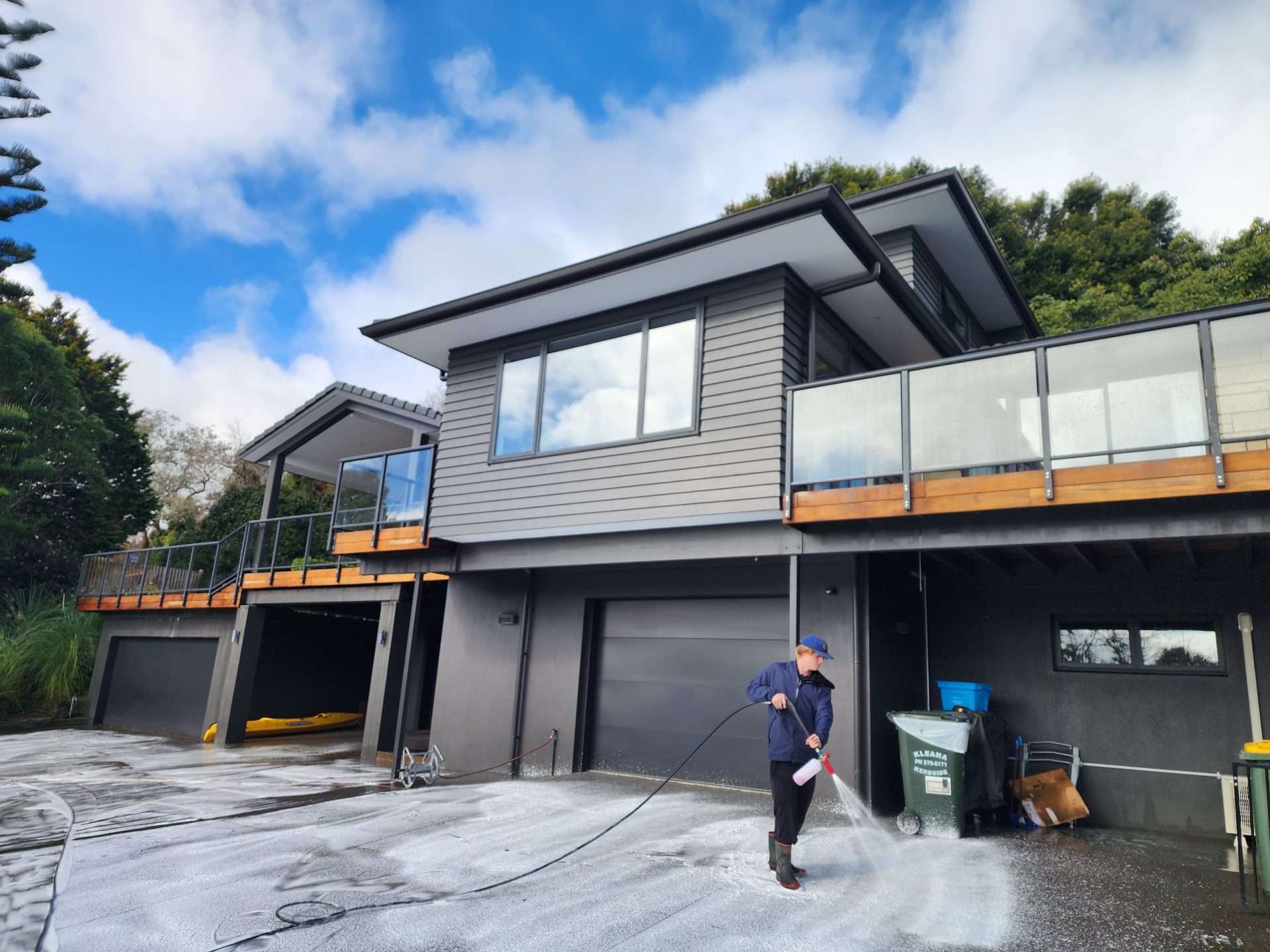 man cleaning a house with a water blaster