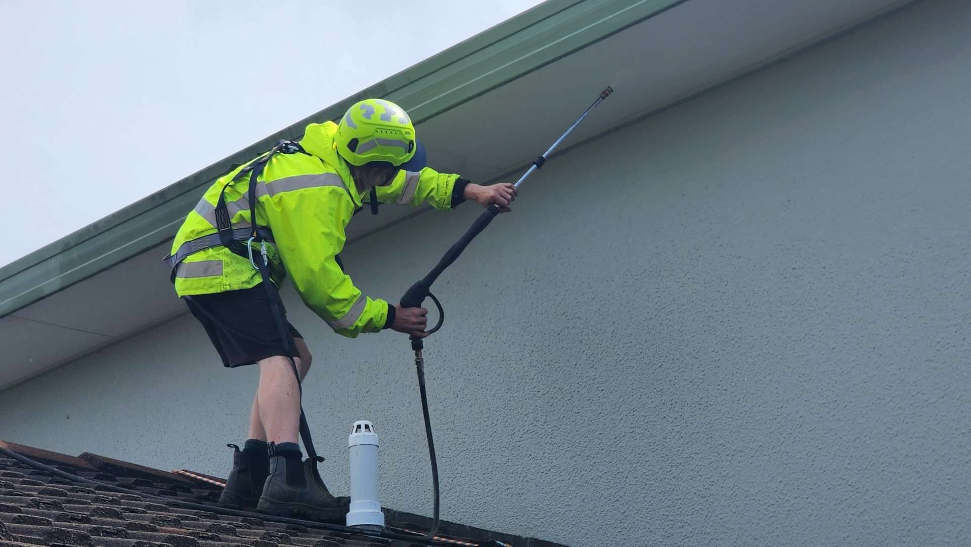 man washing a house with a pressure washer